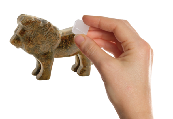 Hand with a wax with a lion carved from soapstone