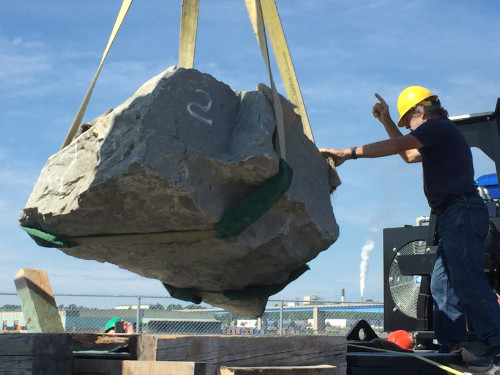 Rock being moved, a man supervising the operation