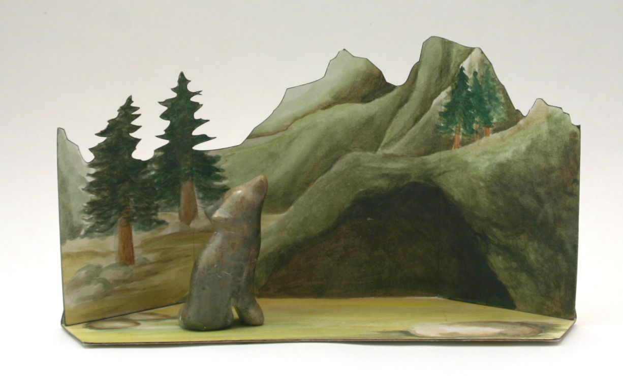 Wolf carved from a soapstone with painted natural background with trees