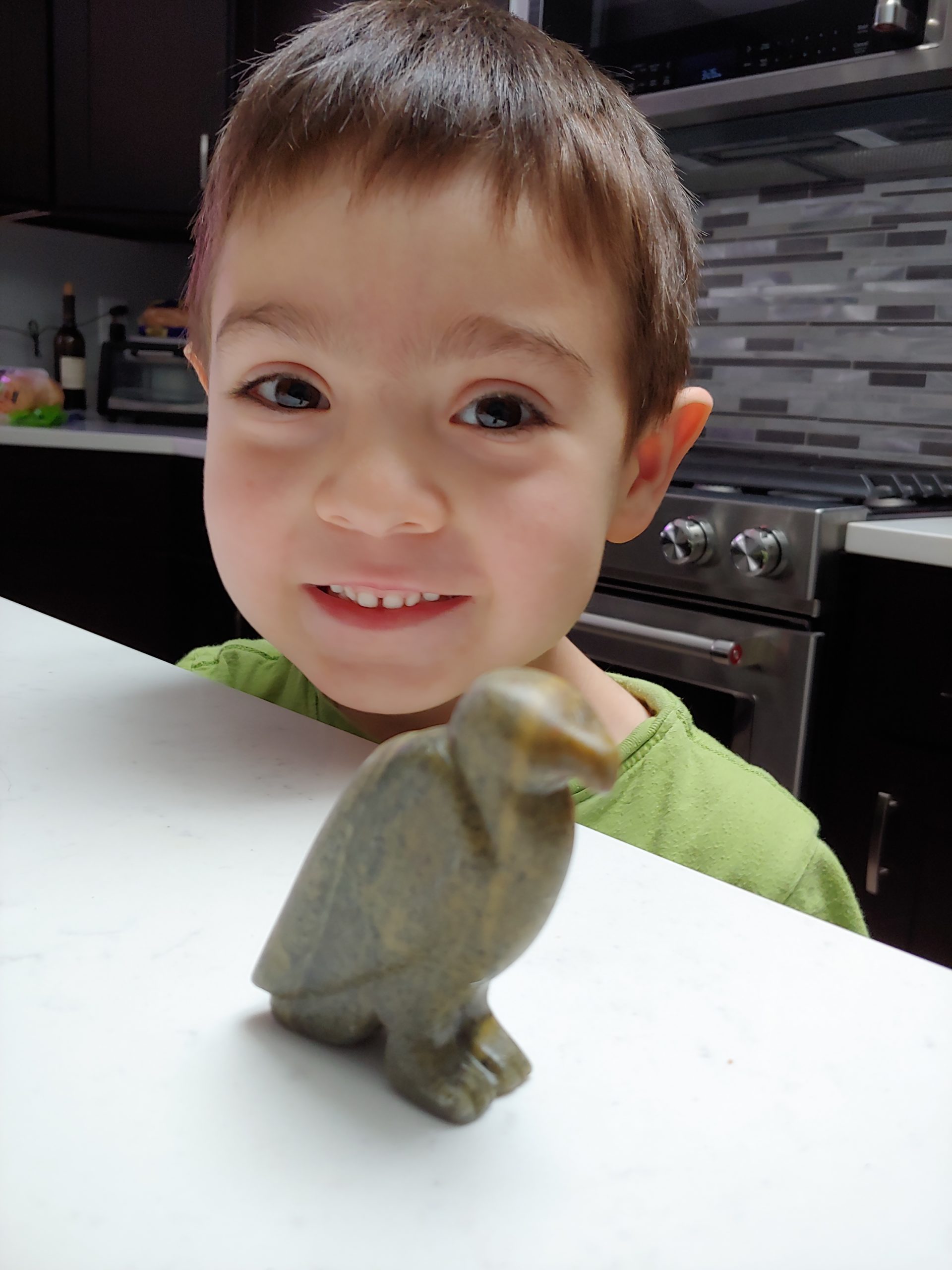 Young boy with a eagle carved from soapstone